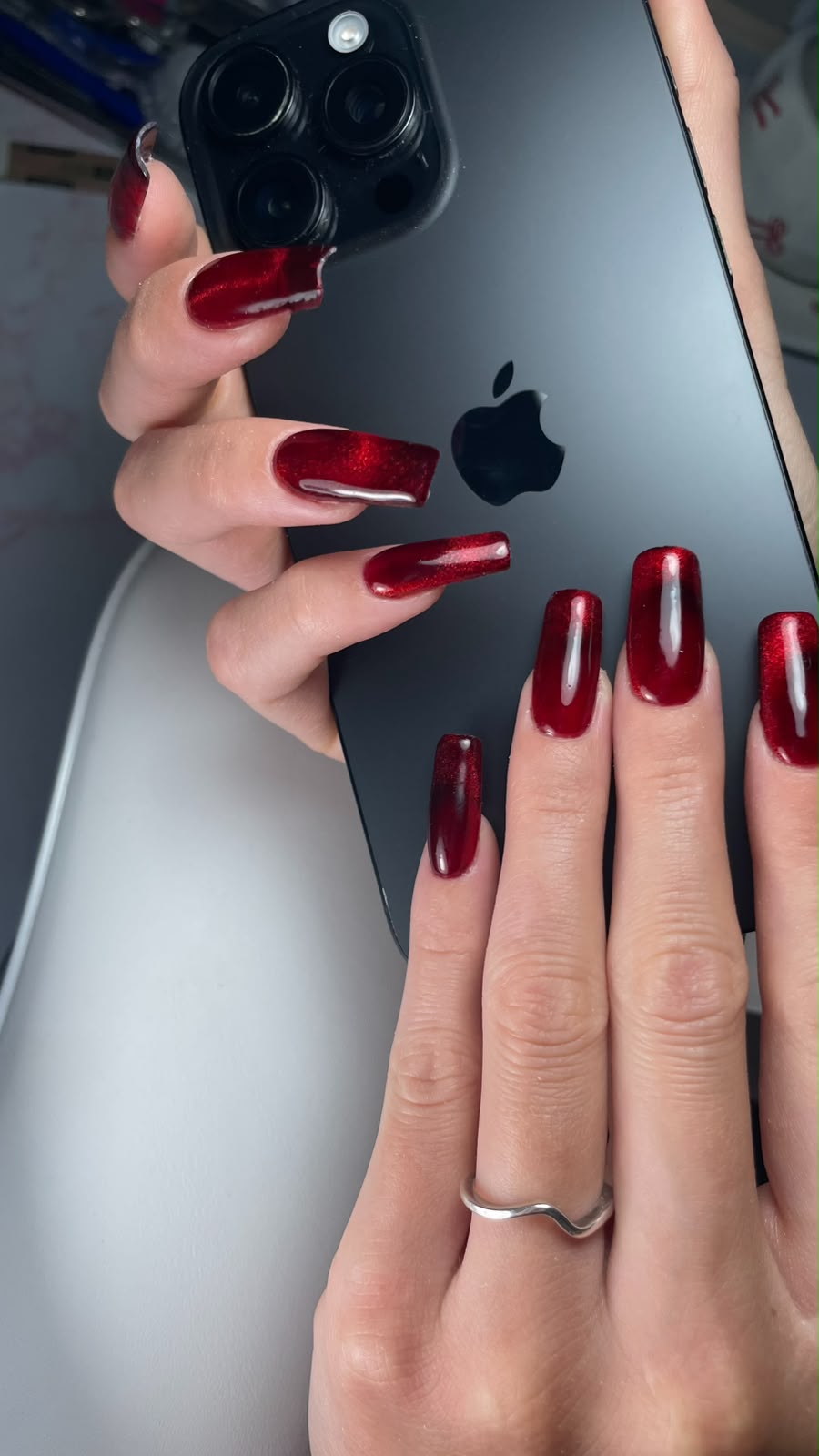Lange Nagelverlängerung in dunklem Weinrot mit Cat-Eye-Effekt